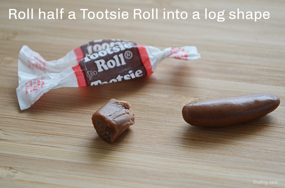Tearing a tootsie roll in half to make a candy hot dog.