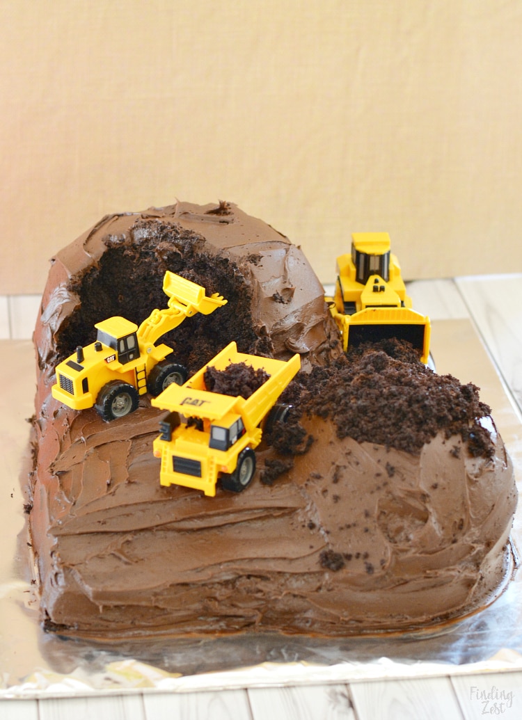 Make this easy construction cake using a chocolate cake mix with chocolate frosting and some toy vehicles. Super easy birthday cake idea for kids!