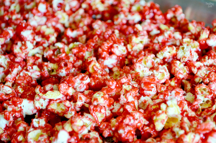 Learn how to make bloody popcorn with bones including directions for adding edible fake blood to your serving dishes! Halloween popcorn has never been so fun and it makes a great snack to serve Halloween party guests!