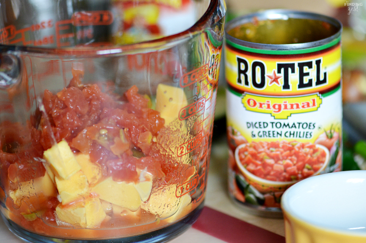 This Loaded Totchos recipe will win the crowd on game day! Perfect for March Madness, these potato rounds are covered in queso dip, refried beans and guacamole!