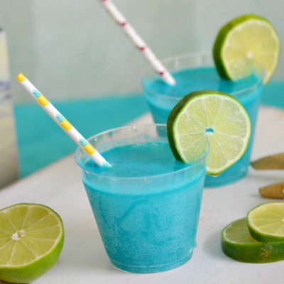 Throwing an mermaid, pool or ocean themed party? This Mermaid Punch recipe is quick and delicious featuring tropical flavors! Your guests will love this blue pina colada punch!