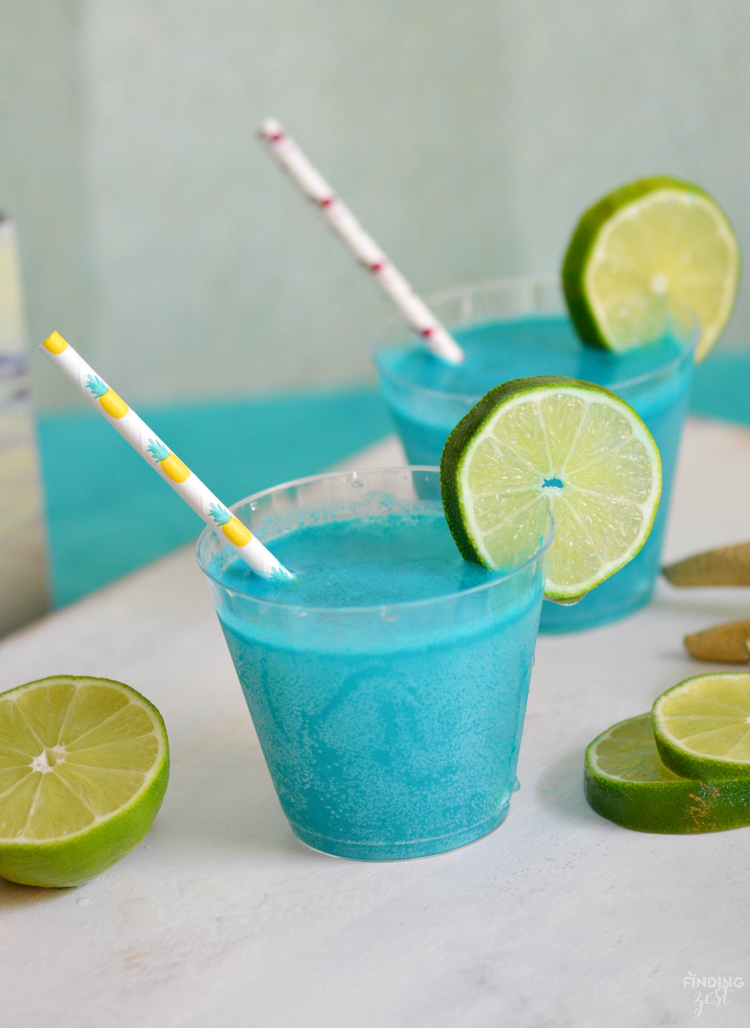 Throwing an mermaid, pool or ocean themed party? This Mermaid Punch recipe is quick and delicious featuring tropical flavors! Your guests will love this blue pina colada punch!