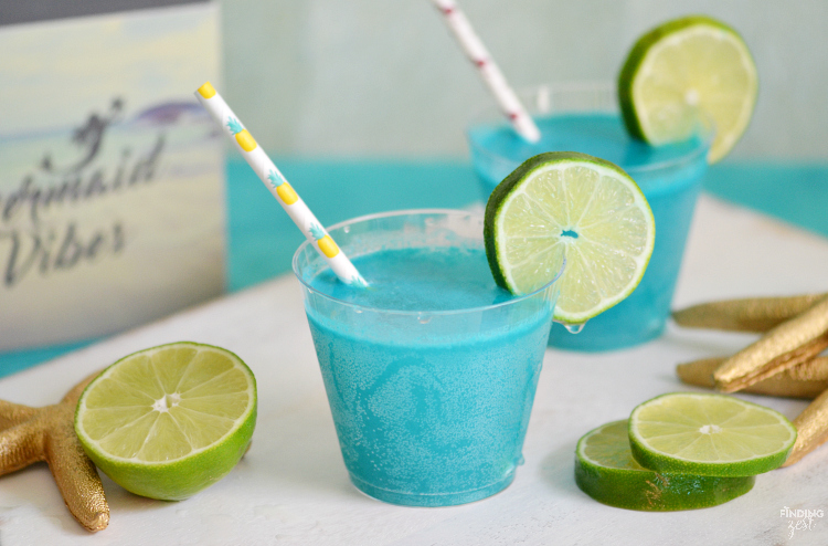Throwing an mermaid, pool or ocean themed party? This Mermaid Punch recipe is quick and delicious featuring tropical flavors! Your guests will love this blue pina colada punch!