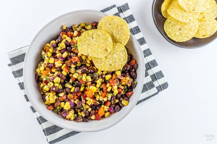 This homemade Black Bean Corn Salsa is sure to be a hit with any crowd! Kick up the flavor to your dinner recipes by serving it as a side dish or as topping to fish, chicken or your favorite Mexican dishes. It also makes for an easy appetizer when served with tortilla chips that everyone will love.