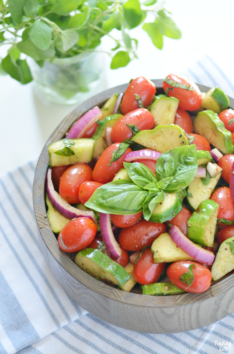 Enjoy this refreshing tomato cucumber salad loaded with fresh herbs, tomatoes, cucumbers, and onion. Let the vegetables marinate in the oil and balsamic vinegar dressing for even more flavor. The perfect side dish for any meal and a great way to use up that fall harvest!