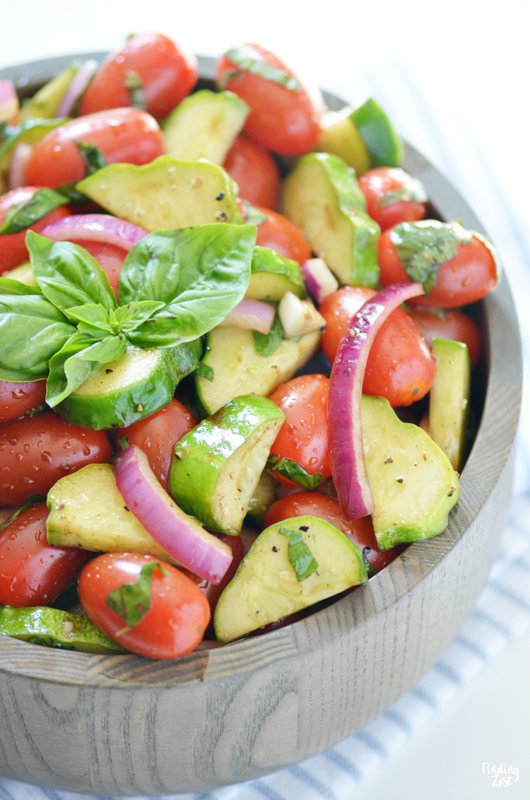 Enjoy this refreshing tomato cucumber salad loaded with fresh herbs, tomatoes, cucumbers, and onion. Let the vegetables marinate in the oil and balsamic vinegar dressing for even more flavor. The perfect side dish for any meal and a great way to use up that fall harvest!