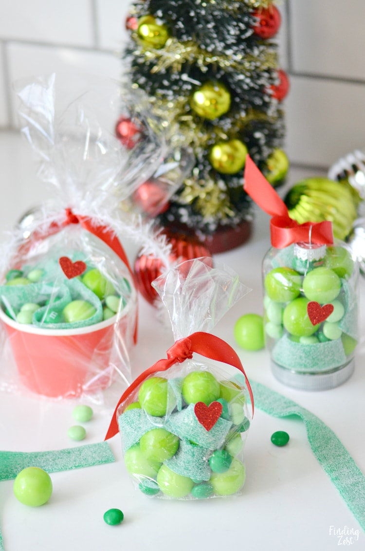Grinch themed Christmas party favors come to life with these three easy ideas! Make your own Grinch ornaments using candy or keep it extra simple with some party bags or snack cups. Either way, they are sure to be a hit with all ages!