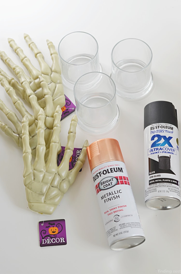 Dollar Tree Halloween Craft Supplies including plastic skeleton hands, glass candle holdersa and spray paint
