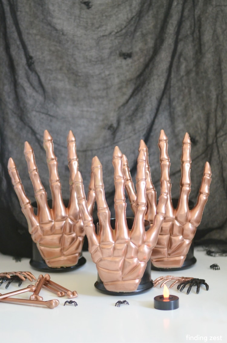 Skeleton Candle Holders are the ultimate Dollar Tree Halloween DIY.  With just a couple of items from the dollar store and some spray paint, you can make modern Halloween decor in whatever colors fit your theme or space!