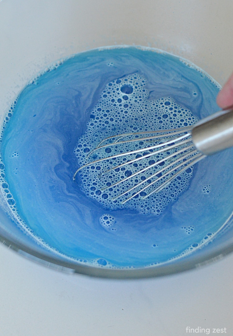 Using a whisk to stir berry blue Jello.