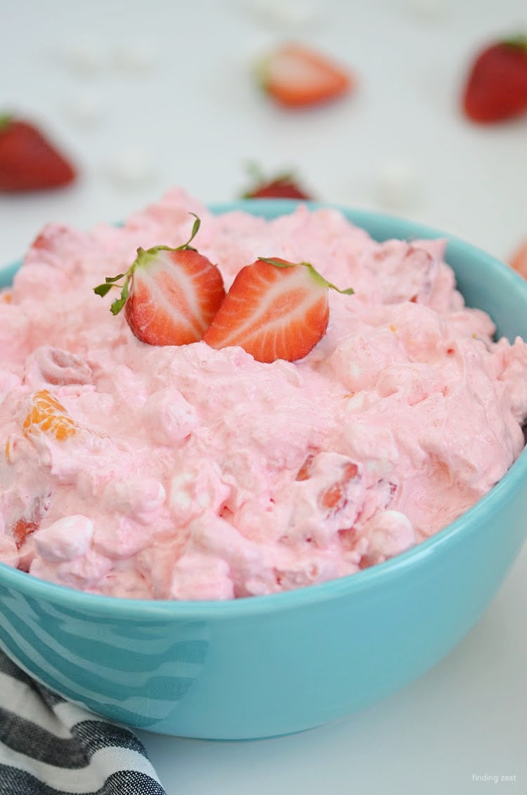 Strawbery Fluff Salad is a refreshing side dish or dessert that is sure to be a hit at your next potluck or holiday gathering! This recipe features fresh strawberries, crushed pineapple, mandarin oranges and mini marshmallows.