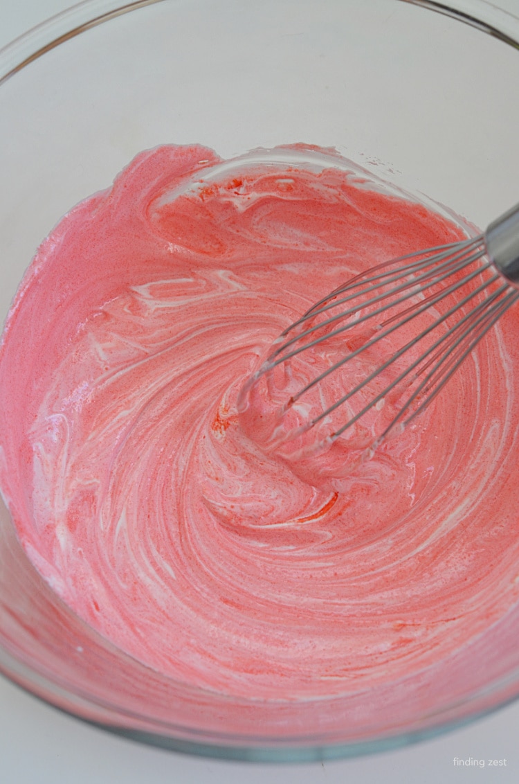 Whisking strawberry Jello mixed with sour cream