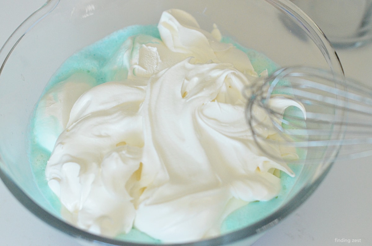 Mixing blue jello and cool whip