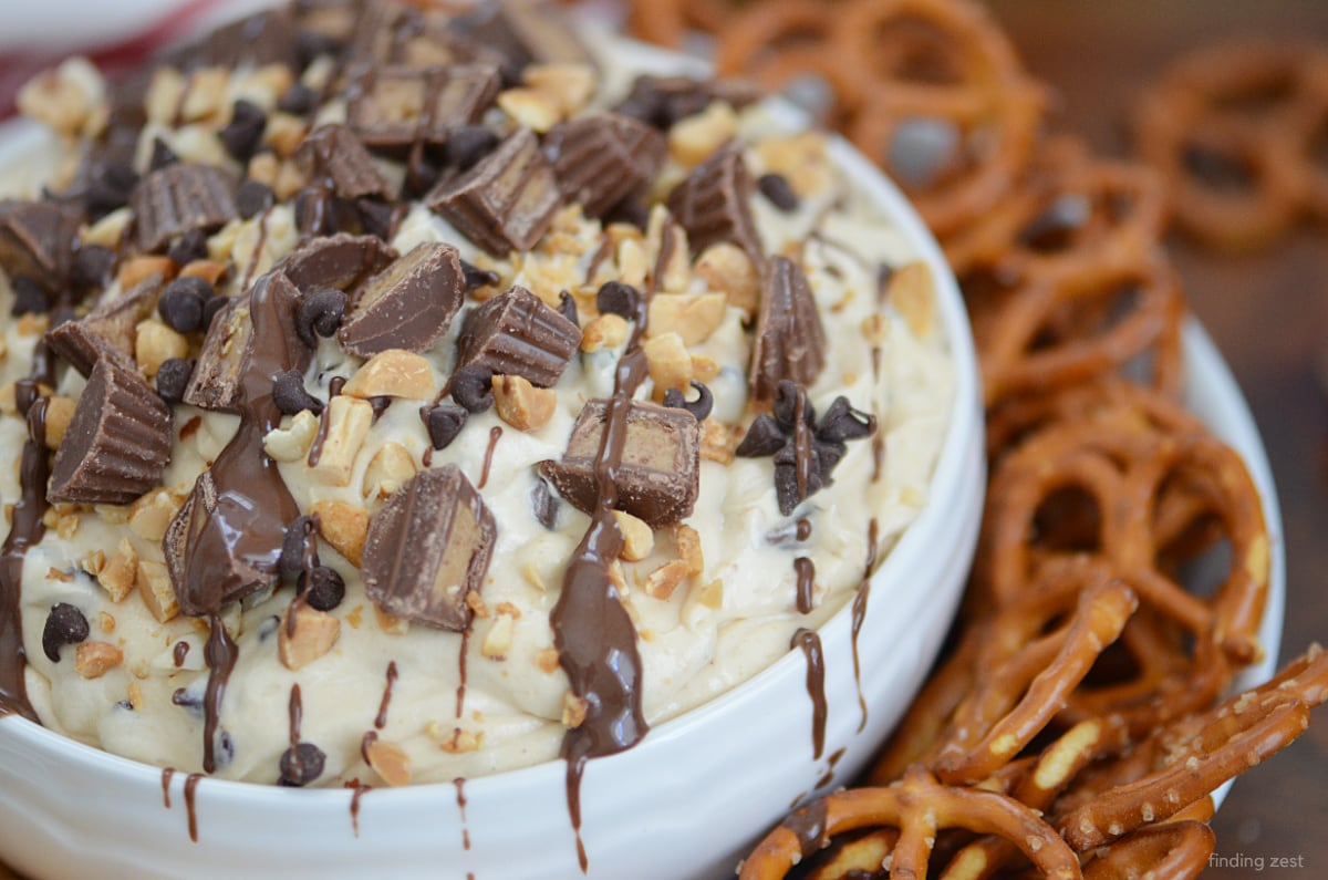This Peanut Butter Dip is a delicious dessert dip that includes peanut butter, cream cheese, whipped topping, and Reese's peanut butter cups!  Serve with vanilla wafers, pretzels, graham crackers or apples for easy dipping.  Peanut butter lovers will rejoice over this easy no-bake dessert!