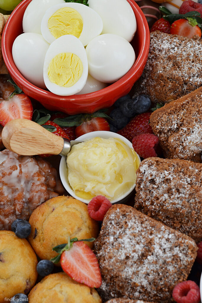 Charcuterie board for breakfast including fresh pastries, eggs and honey butter!