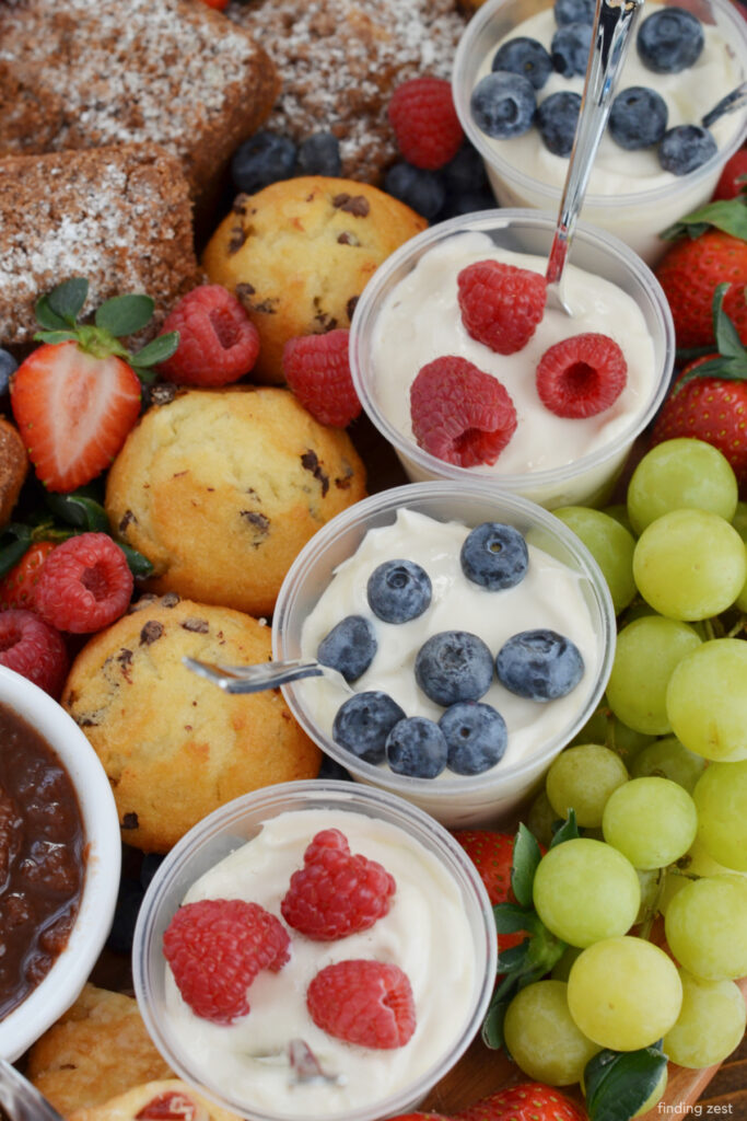 Yogurt Charcuterie board with yogurt parfaits, fresh fruit, eggs and pastries.