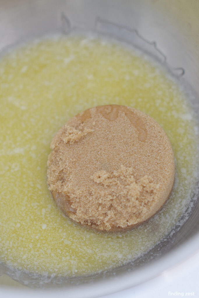 Melted butter and brown sugar in a bowl for a pecan cake recipe