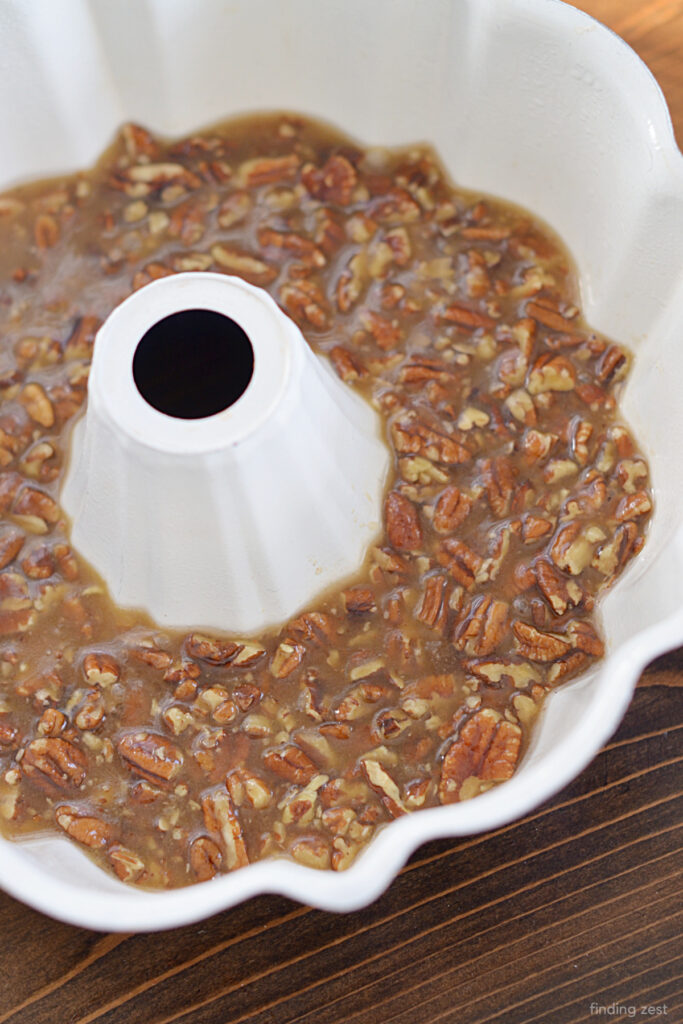 Layering pecan topping in a bundt pan for an upside down cake