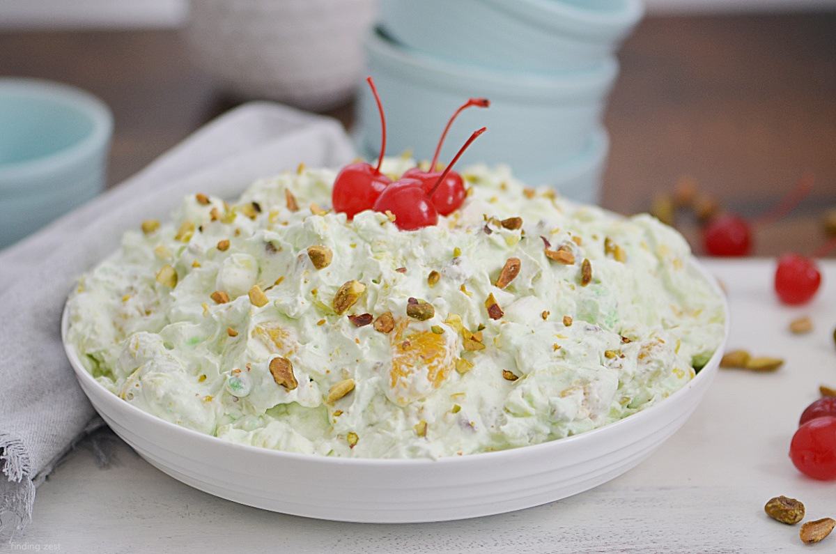 Watergate Salad is a classic side dish or dessert recipe, perfect for any gathering! Everyone will love seeing this light and fluffy fruit salad at your next holiday dinner, cookout or potluck gathering!