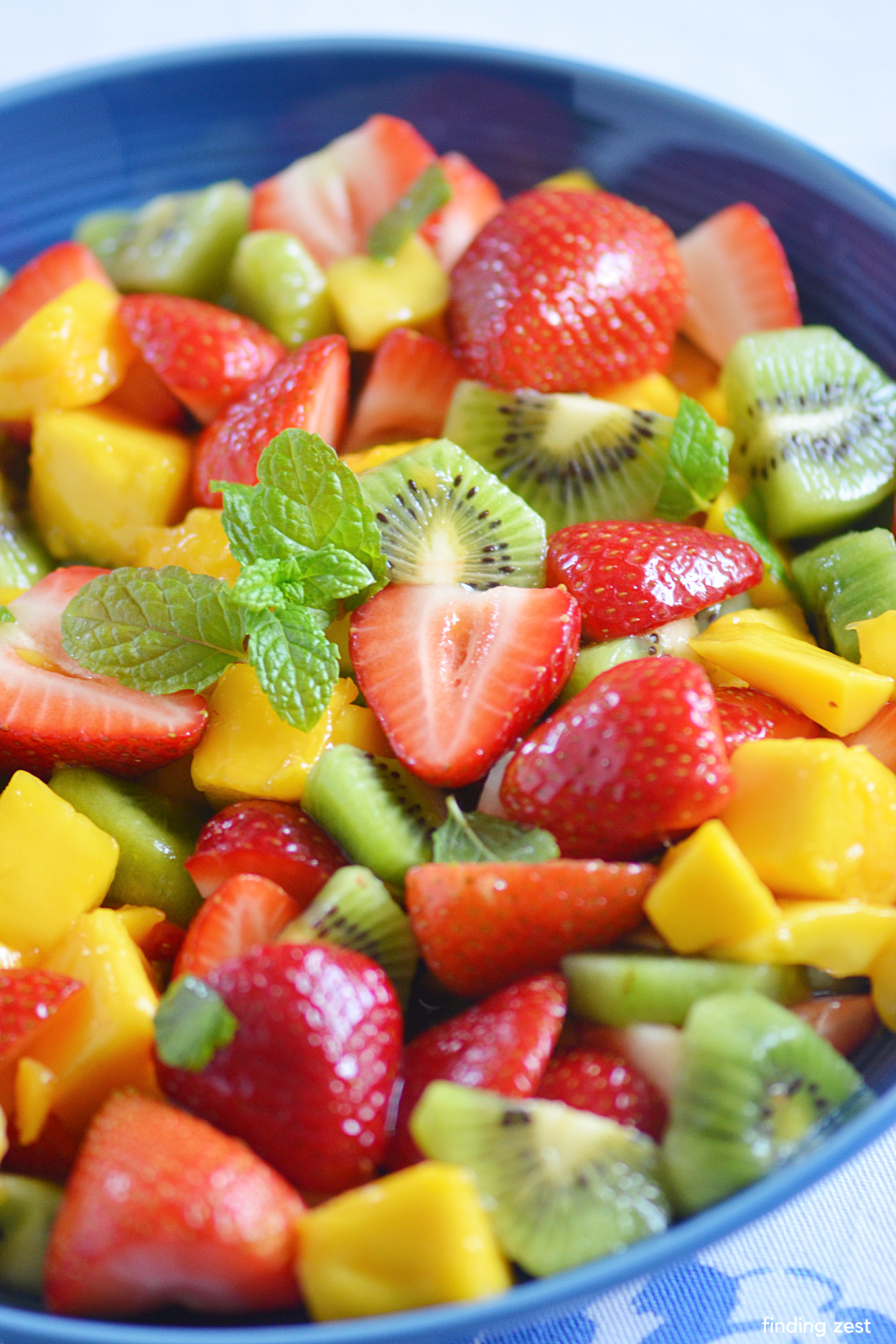 Tropical fruit salad is a super easy and refreshing side dish! Cool off on a hot day with a light salad featuring a pineapple glaze and your favorite summer fruits! While strawberries, mango and kiwi are shown here, you can easily swap them out or add additional fruit varieties.