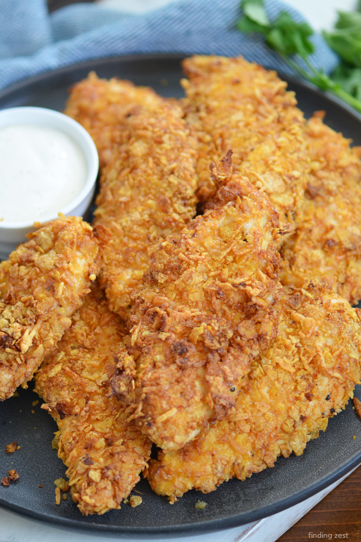 Air Fryer Chicken Tenders are the ultimate party appetizer, game day snack or dinner the whole family will love! Crunchy, juicy and delicious, these homemade chicken tenders are easy to make and feature cornflakes and parmesan cheese! No oil needed when you make these chicken tenders in the air fryer. Perfect for dunking in ranch dressing, honey mustard or bbq sauce!