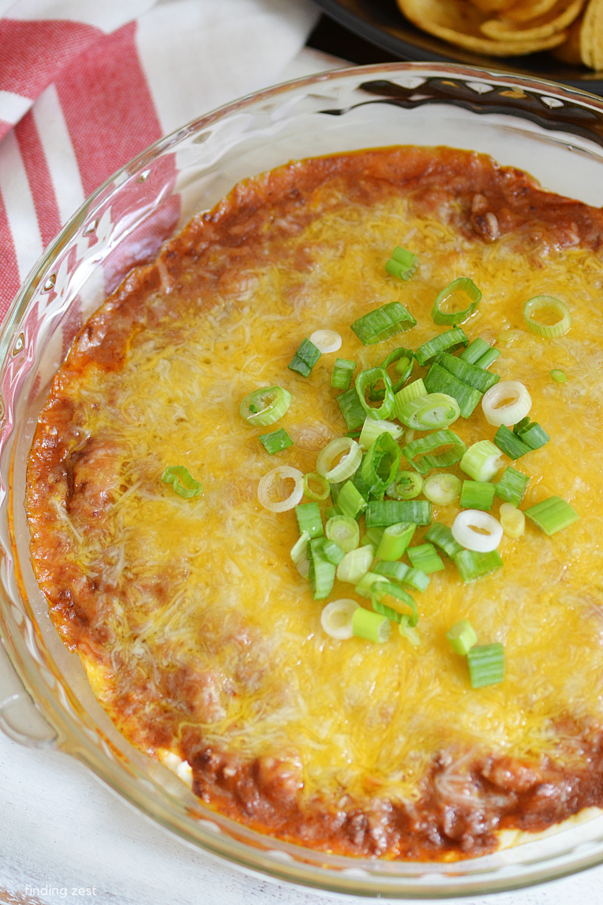 This chili cheese dip is a party favorite! Serve it warm out of the oven with your favorite tortilla chips for a delicious appetizer or snack. It features layers of creamy cream cheese, hearty canned chili, and melted shredded cheese! So good!