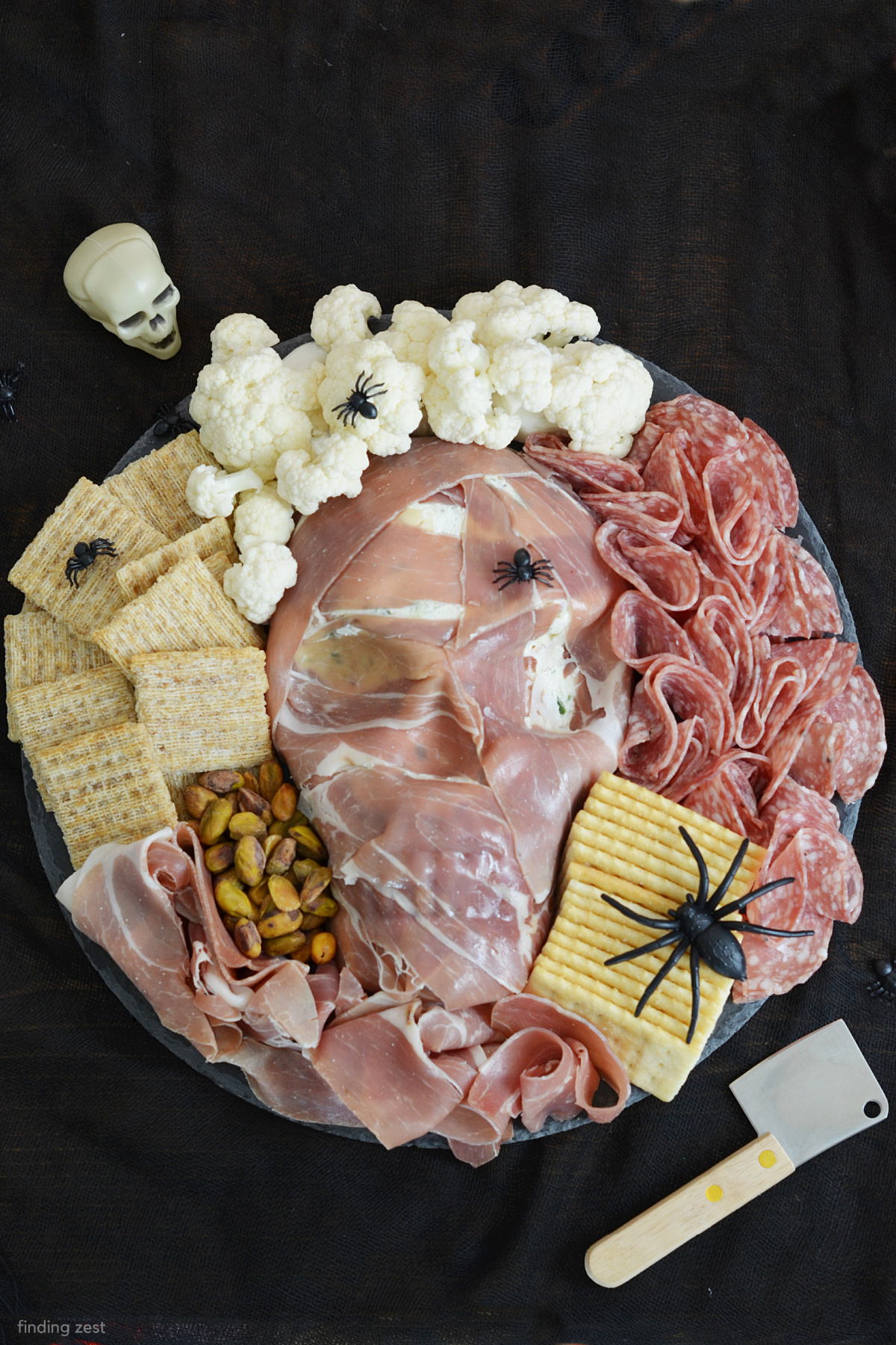 This Spooky Halloween Charcuterie Board is sure to be the star of your next Halloween Party! It features a skull cheese ball wrapped in prosciutto for a creepy but delicious centerpiece. Easy to make with step-by step instructions. Give this spooky Halloween appetizer a try!