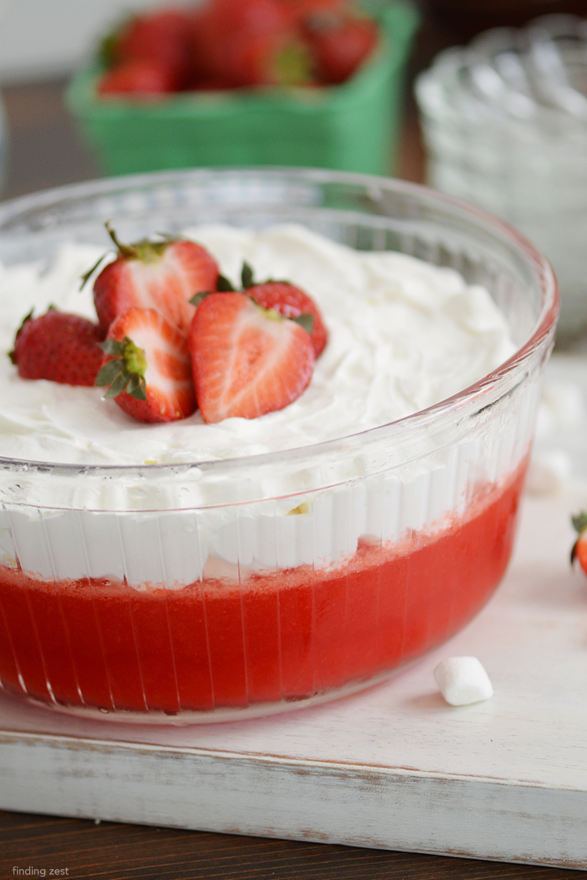 Applesauce Jello is a light and fruity jello salad with unsweetened applesauce and a splash of Sprite. It a great combination of sparkle and tang! This strawberry jello is finished off with cremay Cool Whip and mini marshmallows that makes a festive jello. It's perfect for holiday parties and potlucks year-round!