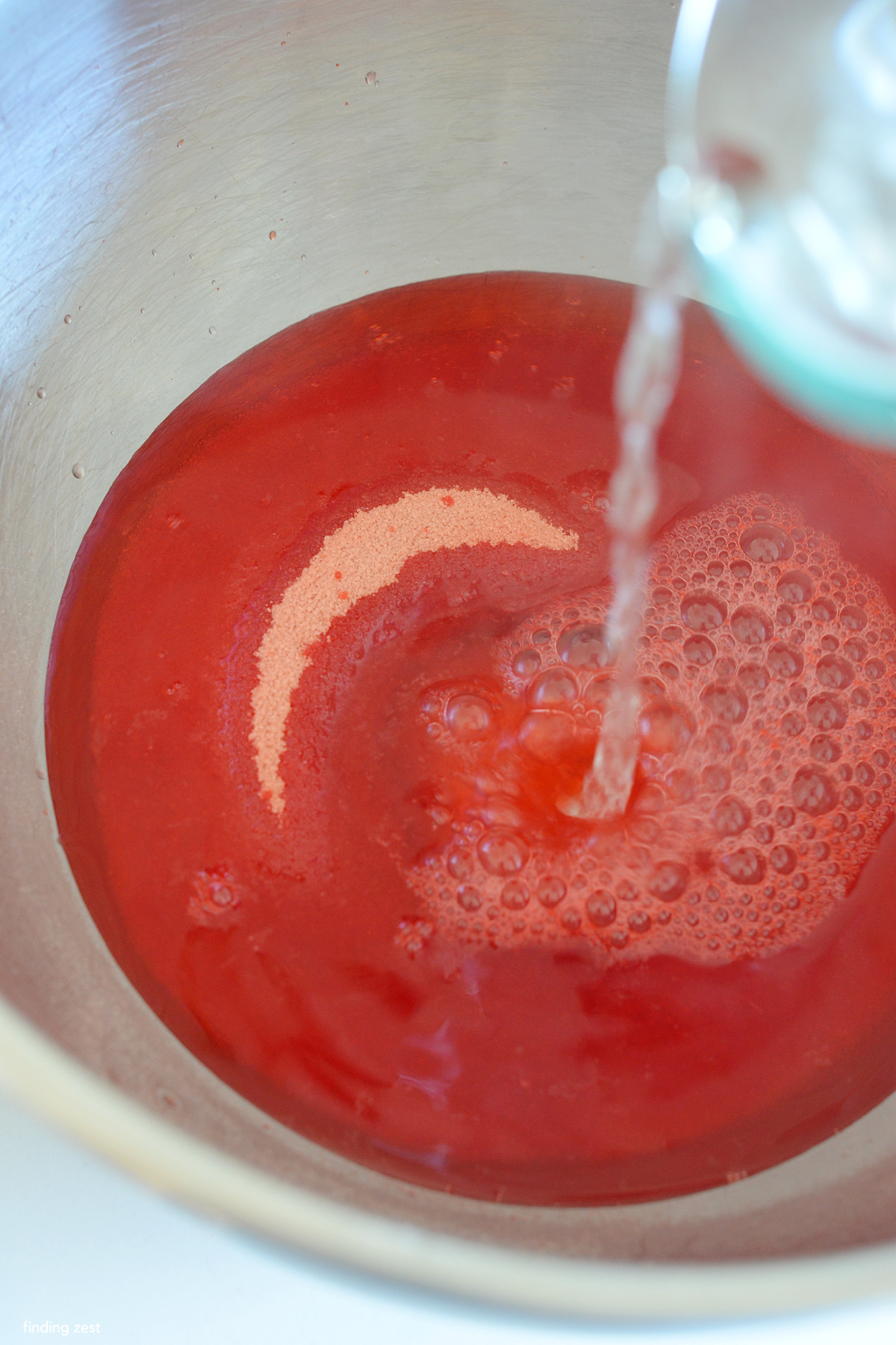 Pouring boiling water on strawberry jello.